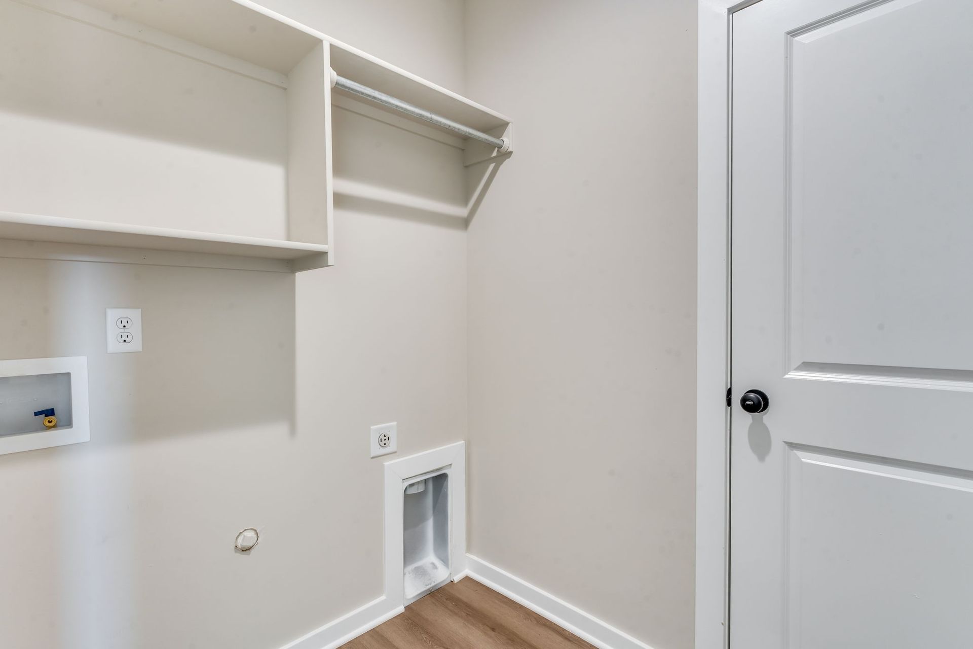 A laundry room with a washer and dryer and a door.