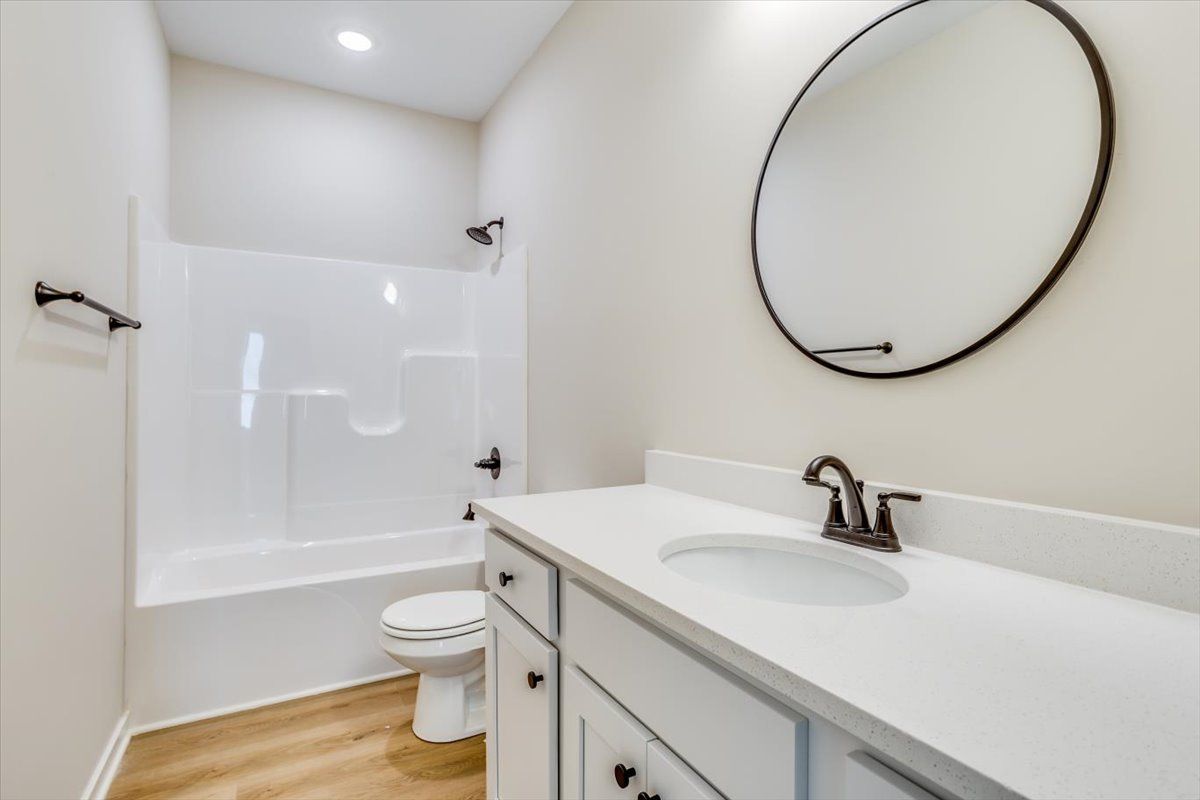 A bathroom with a sink , toilet , and mirror