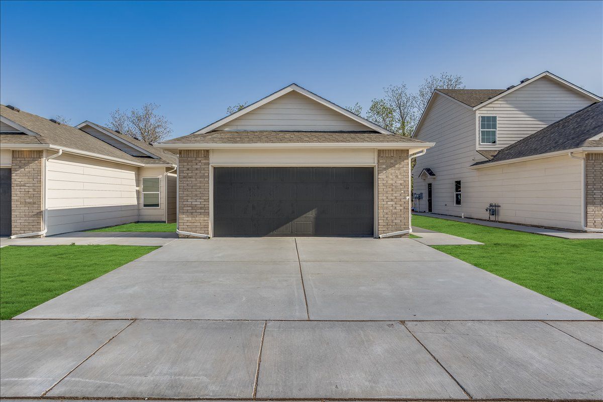A house with two garages and a concrete driveway