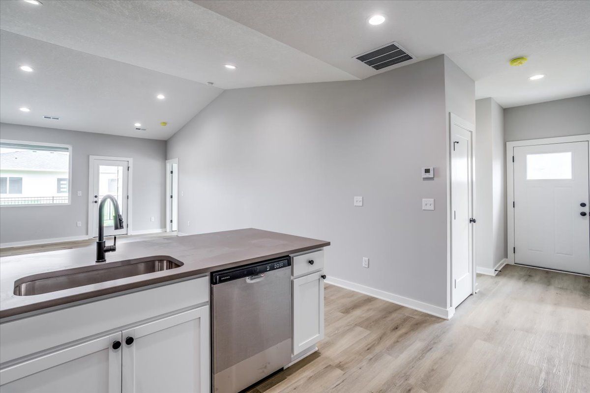 A kitchen with a sink , dishwasher , and stainless steel appliances.