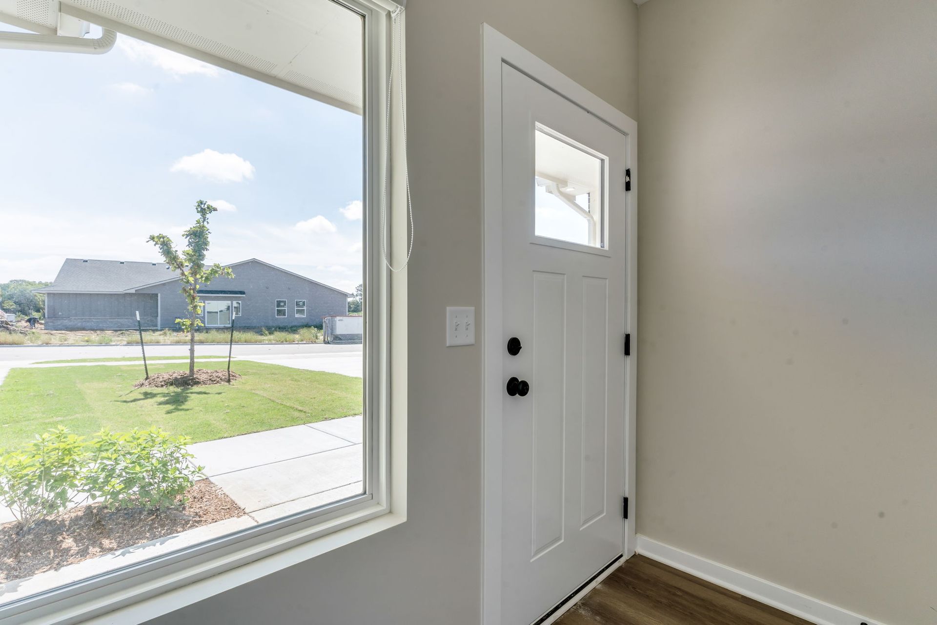 A white door is sitting in a room next to a window.