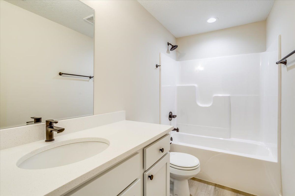 A bathroom with a sink toilet and bathtub