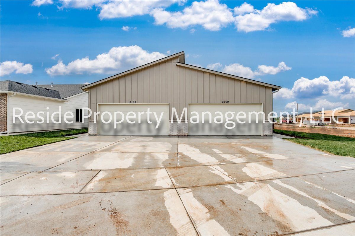 A large garage with a concrete driveway in front of it.