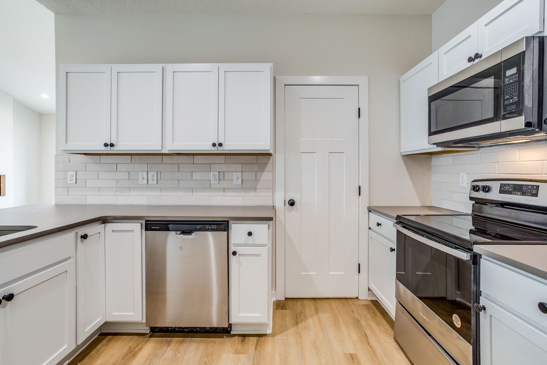 A kitchen with white cabinets and stainless steel appliances.