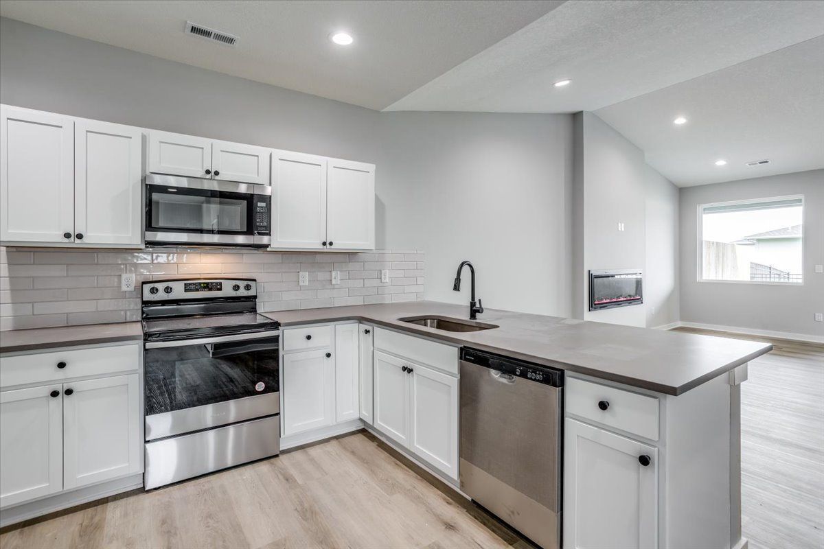 A kitchen with white cabinets and stainless steel appliances.