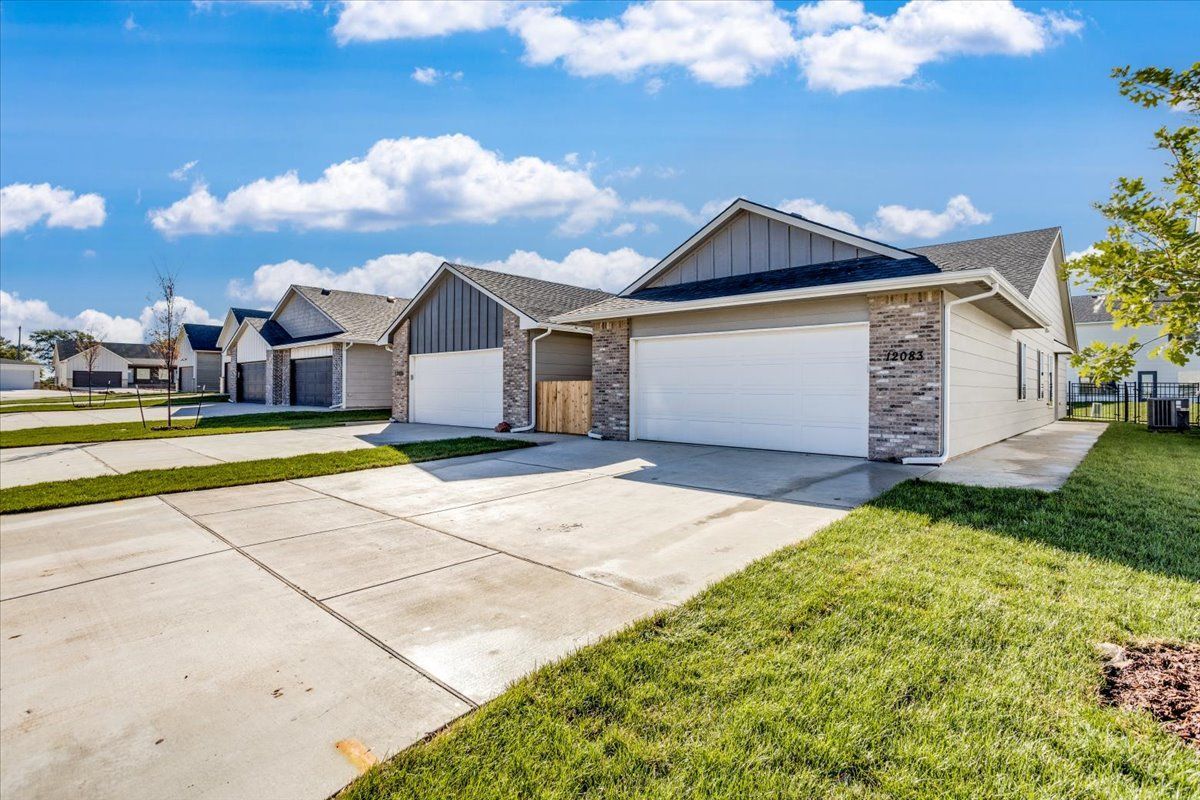 A row of houses with white garage doors in a residential neighborhood.