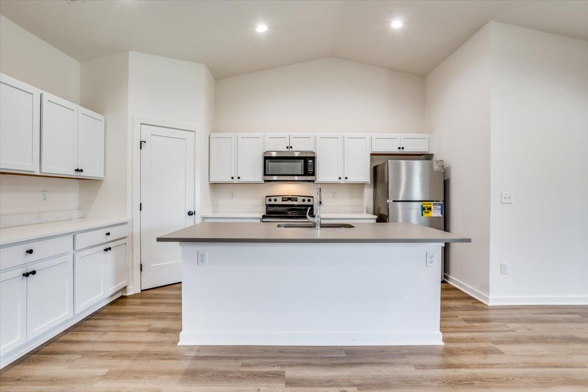 A kitchen with white cabinets and stainless steel appliances