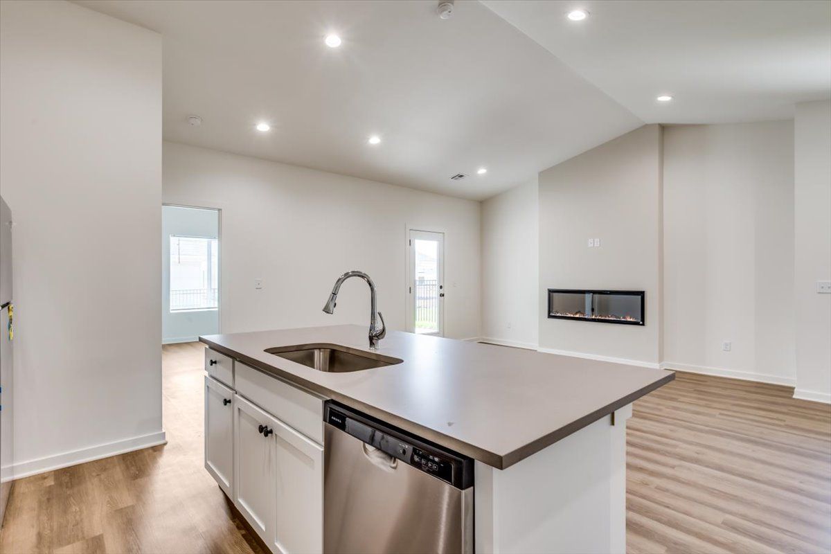 A kitchen with a sink , dishwasher , and stainless steel appliances.