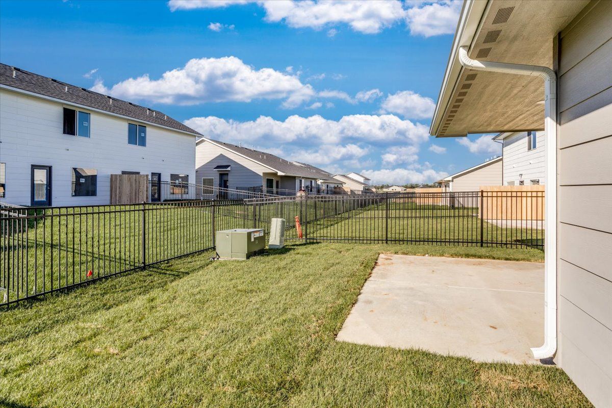 There is a fence around the backyard of a house.