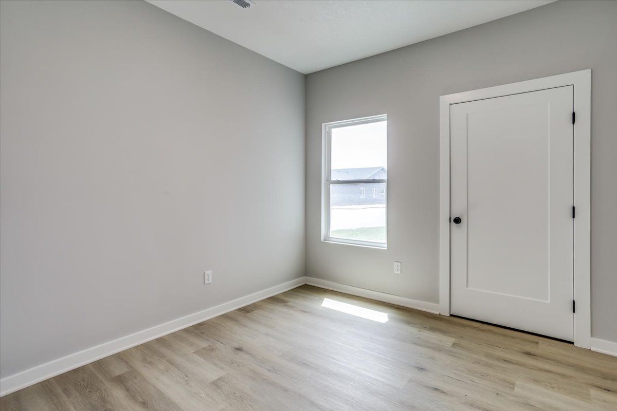 An empty room with a window and a door.