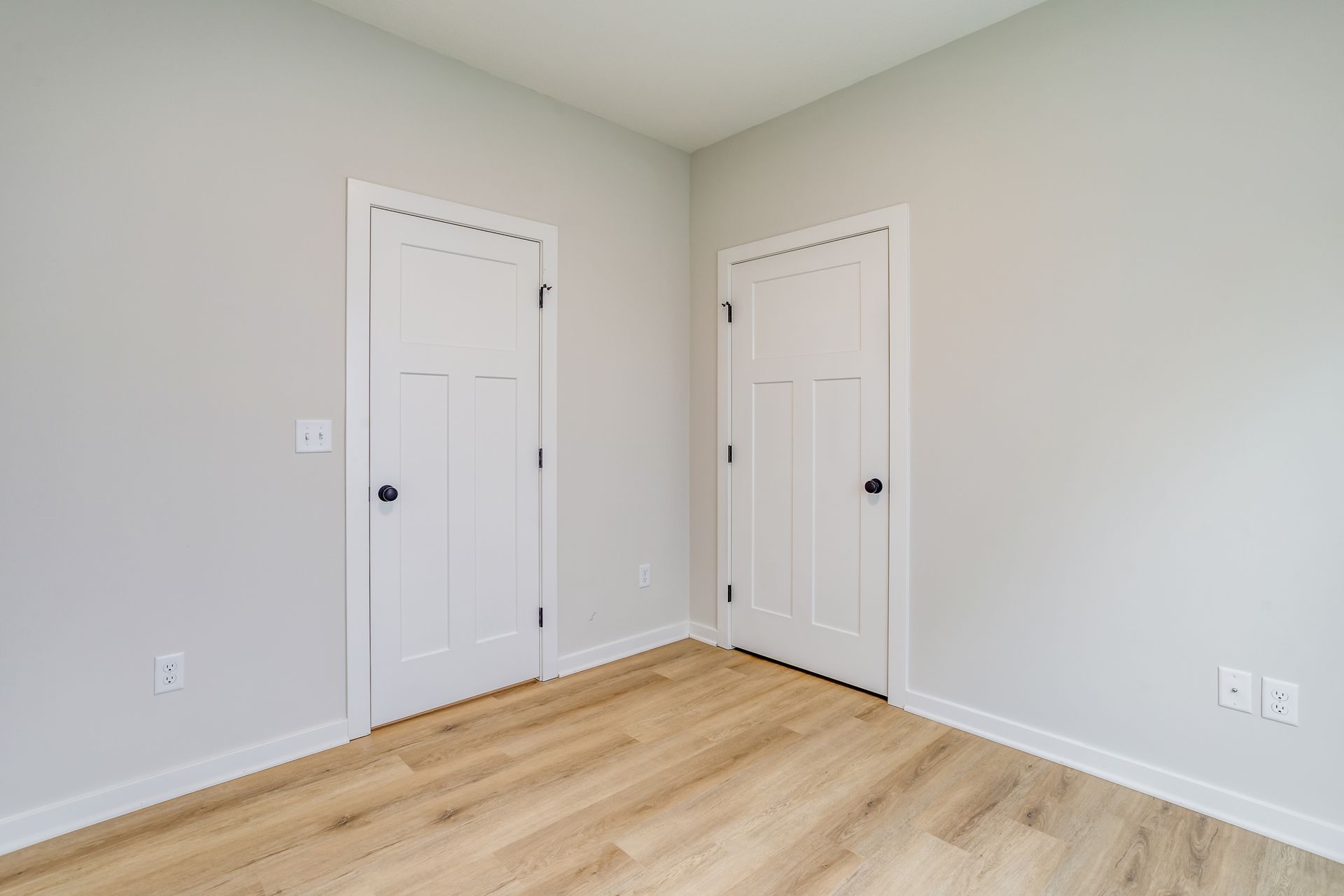 There are two doors in the corner of the room.