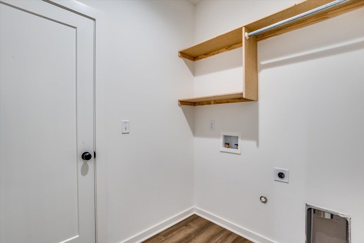 A laundry room with wooden shelves and a door.