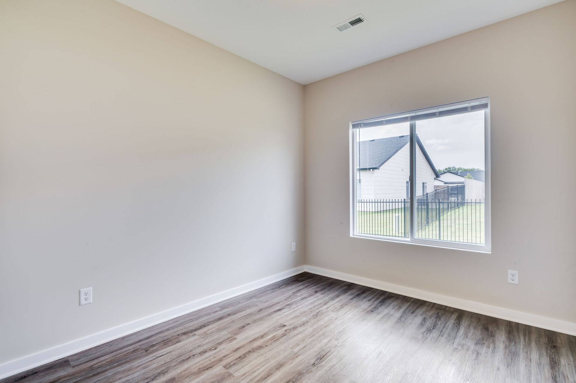 An empty room with hardwood floors and a window.