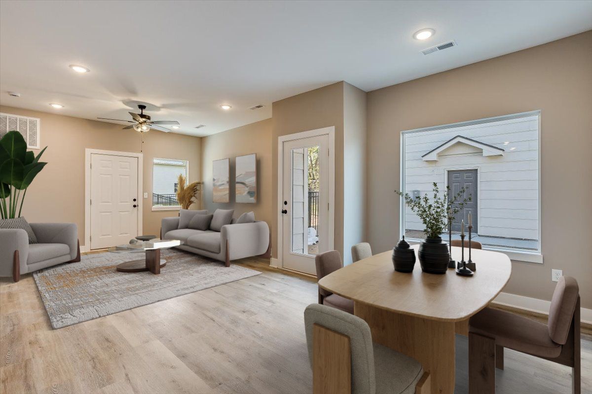 A living room with a couch , chairs , a table and a window.