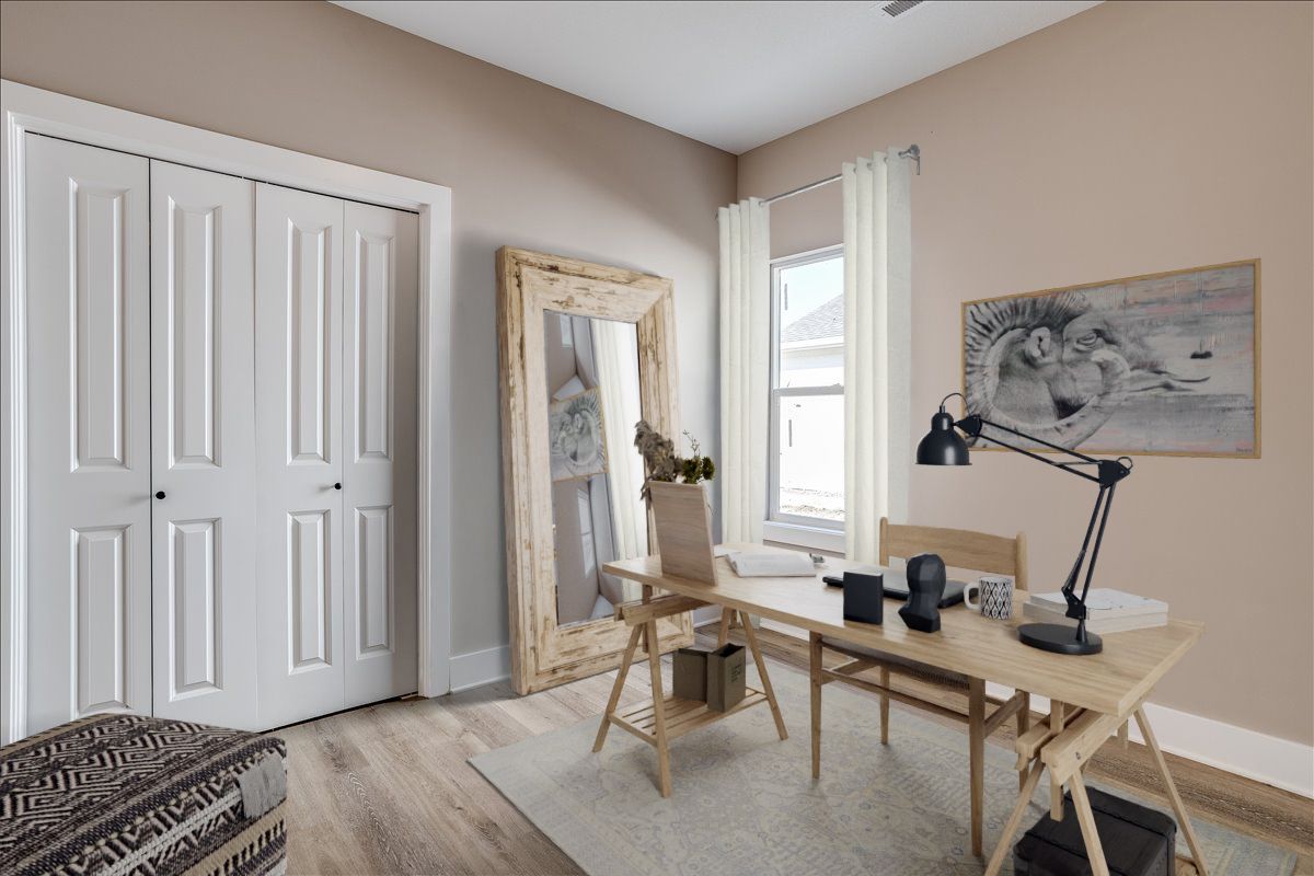 A room with a desk , chairs , a mirror and a lamp.