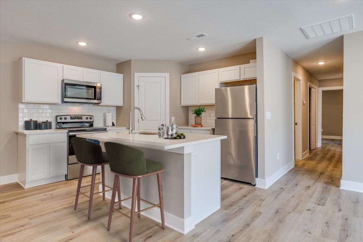 A kitchen with stainless steel appliances and white cabinets