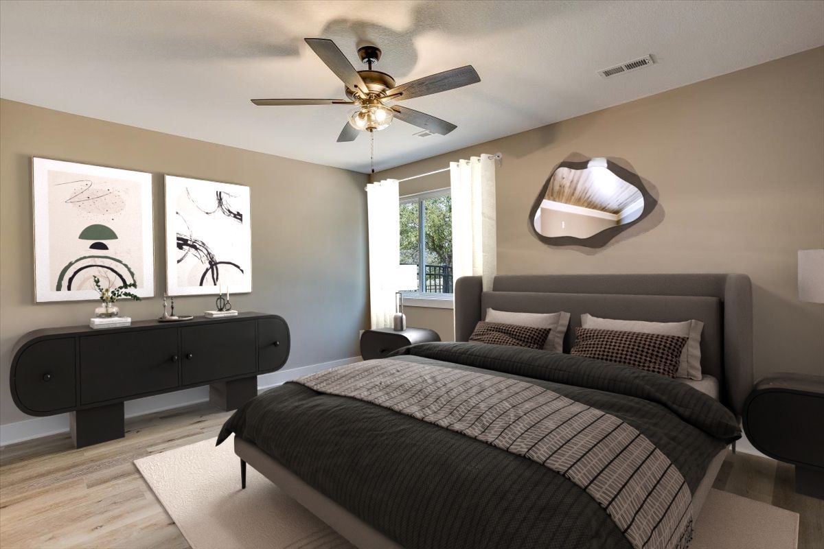 A bedroom with a large bed and a ceiling fan.