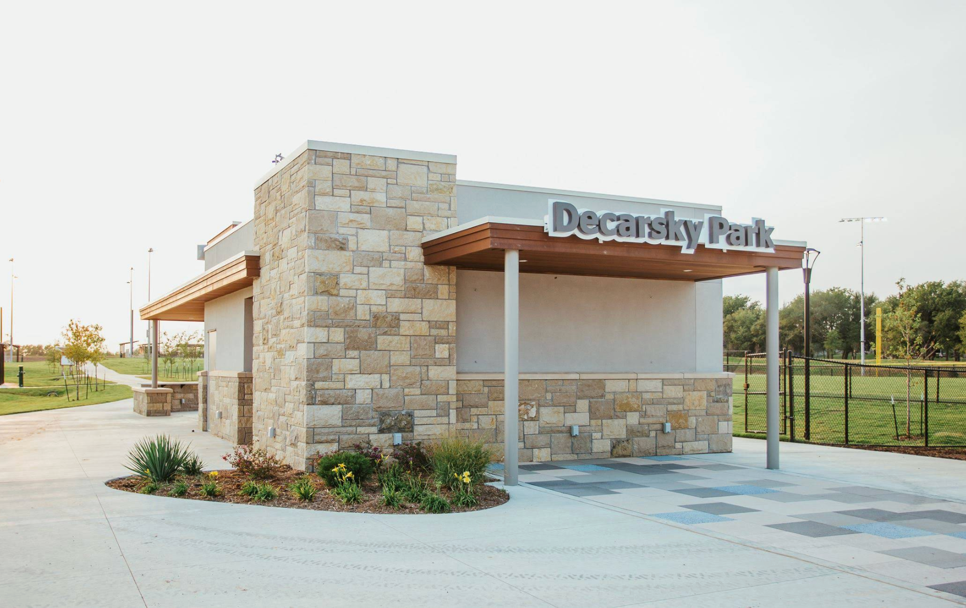 A small building with a stone wall and a sign that says deceased park.