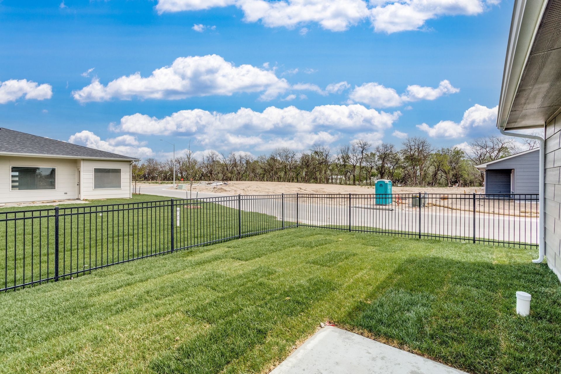 There is a fence around the backyard of a house.