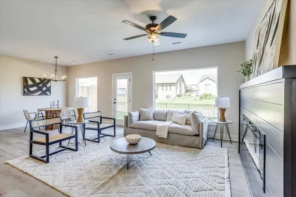 A living room with a couch , chairs , coffee table and fireplace.