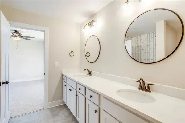 A bathroom with two sinks and two mirrors.