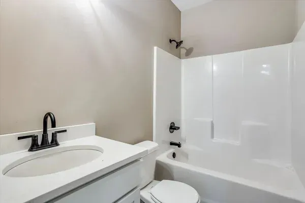 A bathroom with a sink , toilet and bathtub.