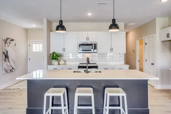 A kitchen with a large island and three stools