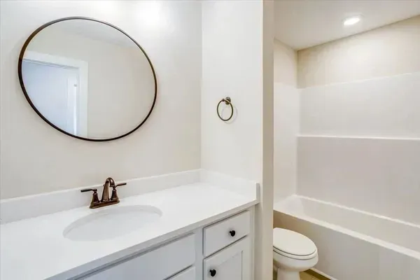 A bathroom with a sink , toilet , and bathtub.