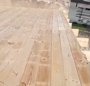 Pizza cubierta con tomates y aceitunas sobre una tabla de madera.