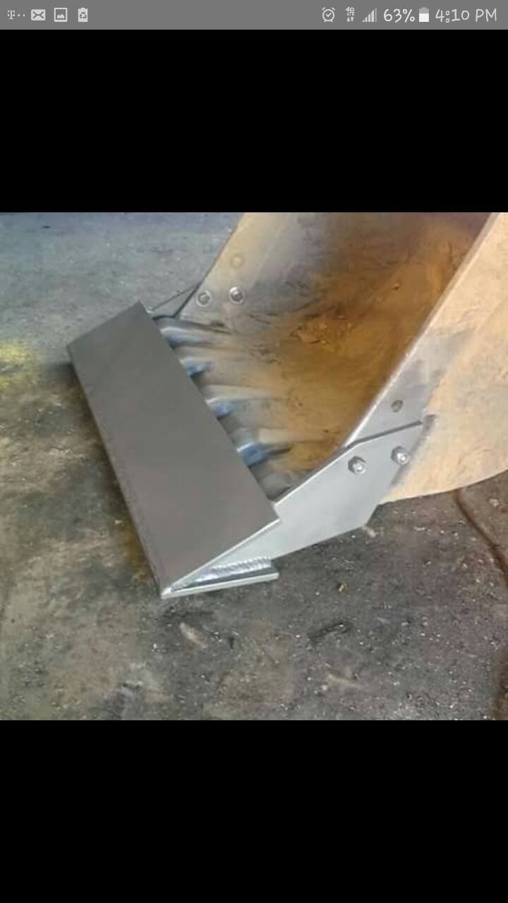 A close up of a bulldozer bucket on the ground.