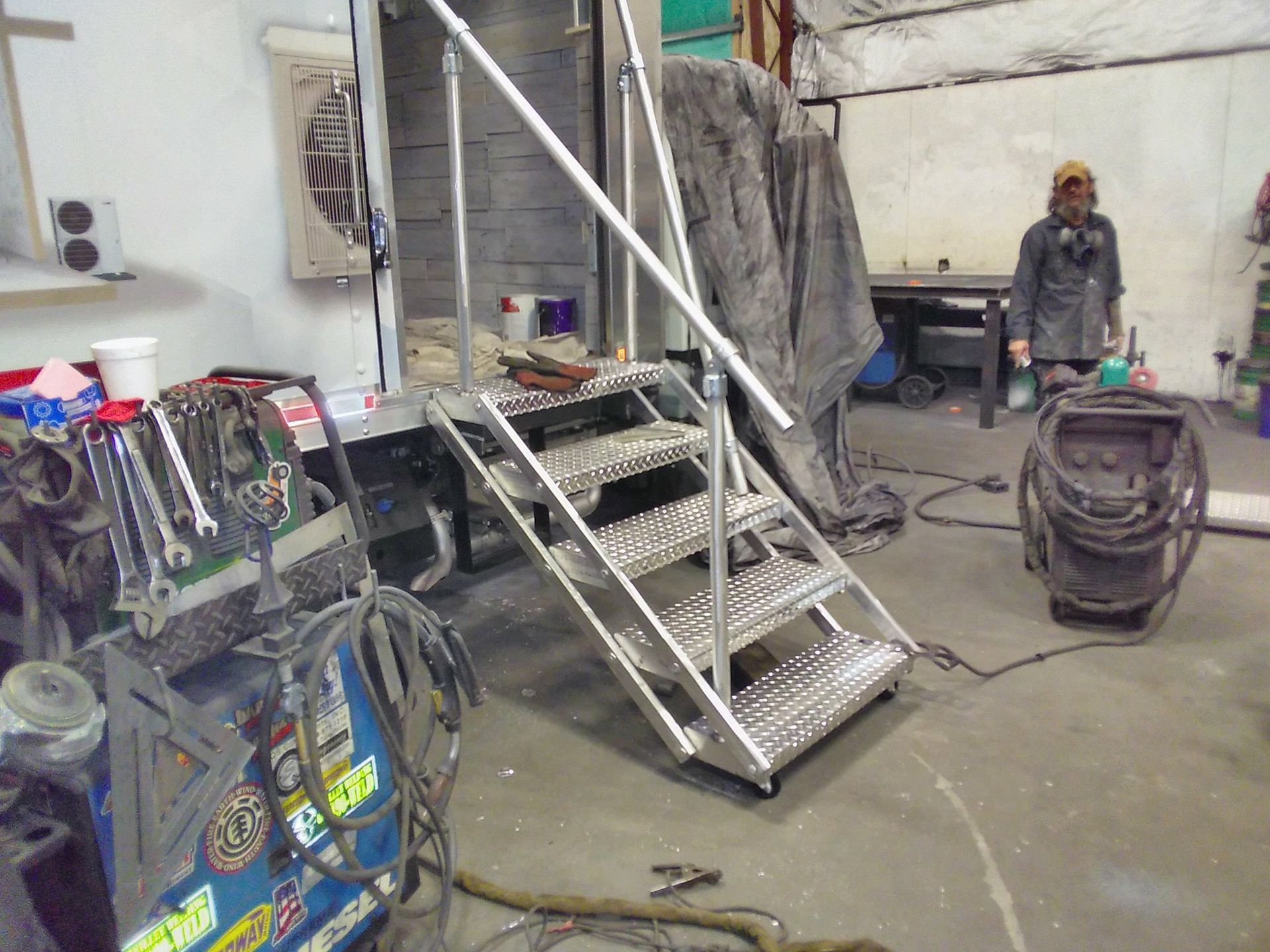 A metal staircase is being built in a garage.