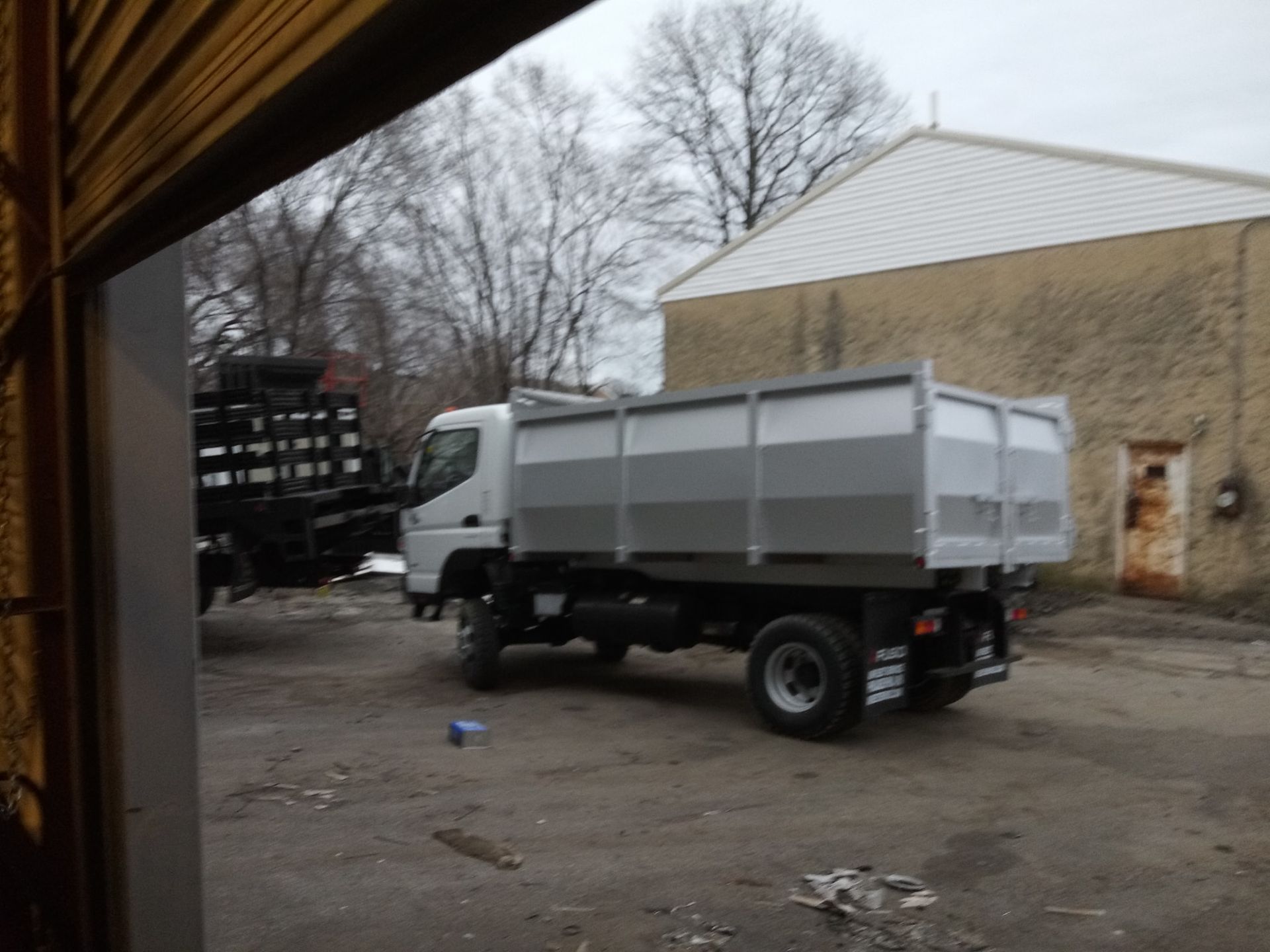 A dump truck is parked in front of a building
