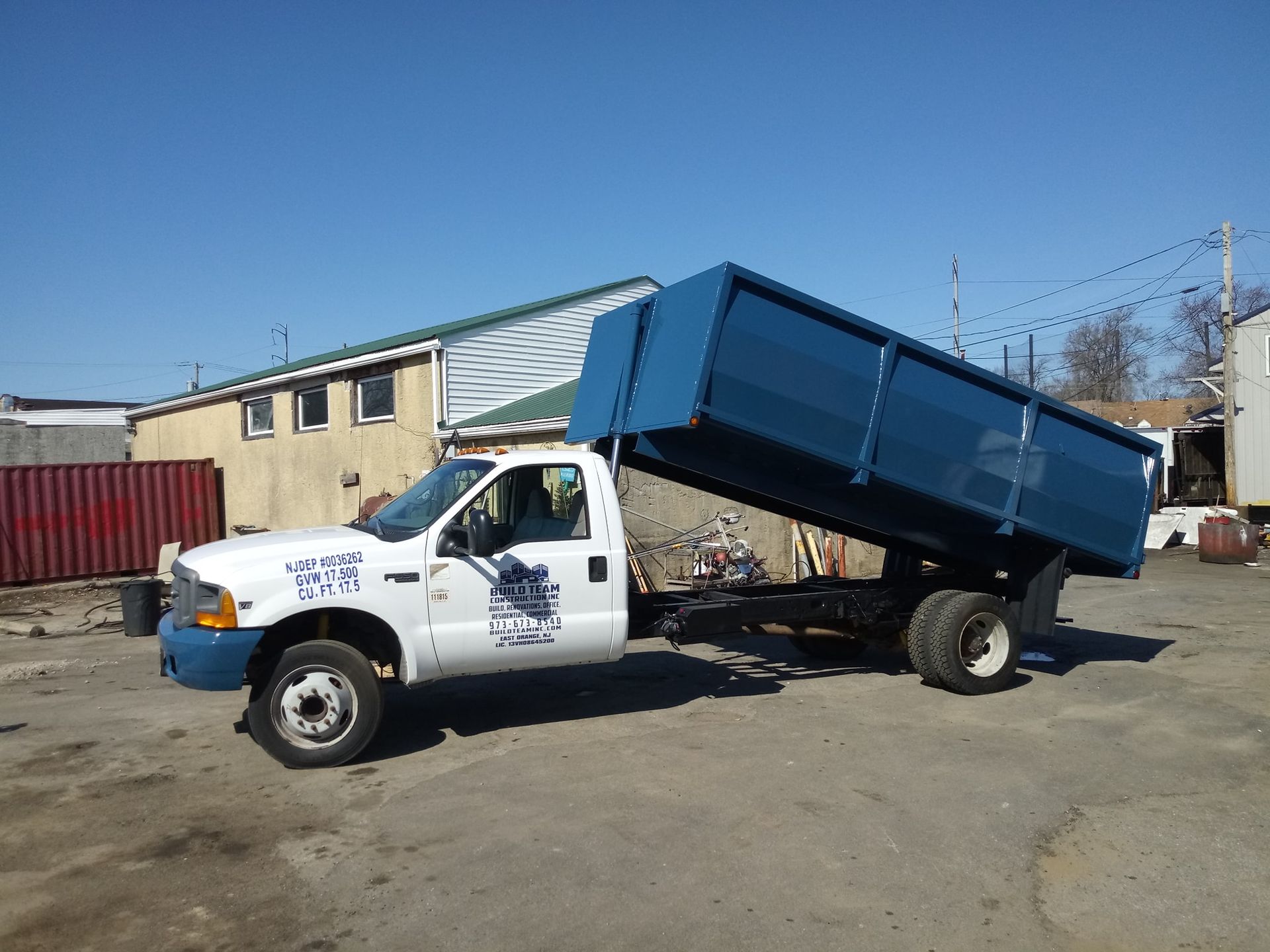 A dump truck is parked in a parking lot with its bed open.