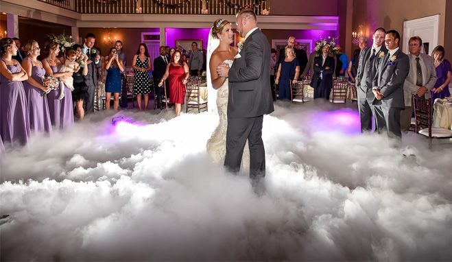 A bride and groom are dancing in the clouds at their wedding reception.