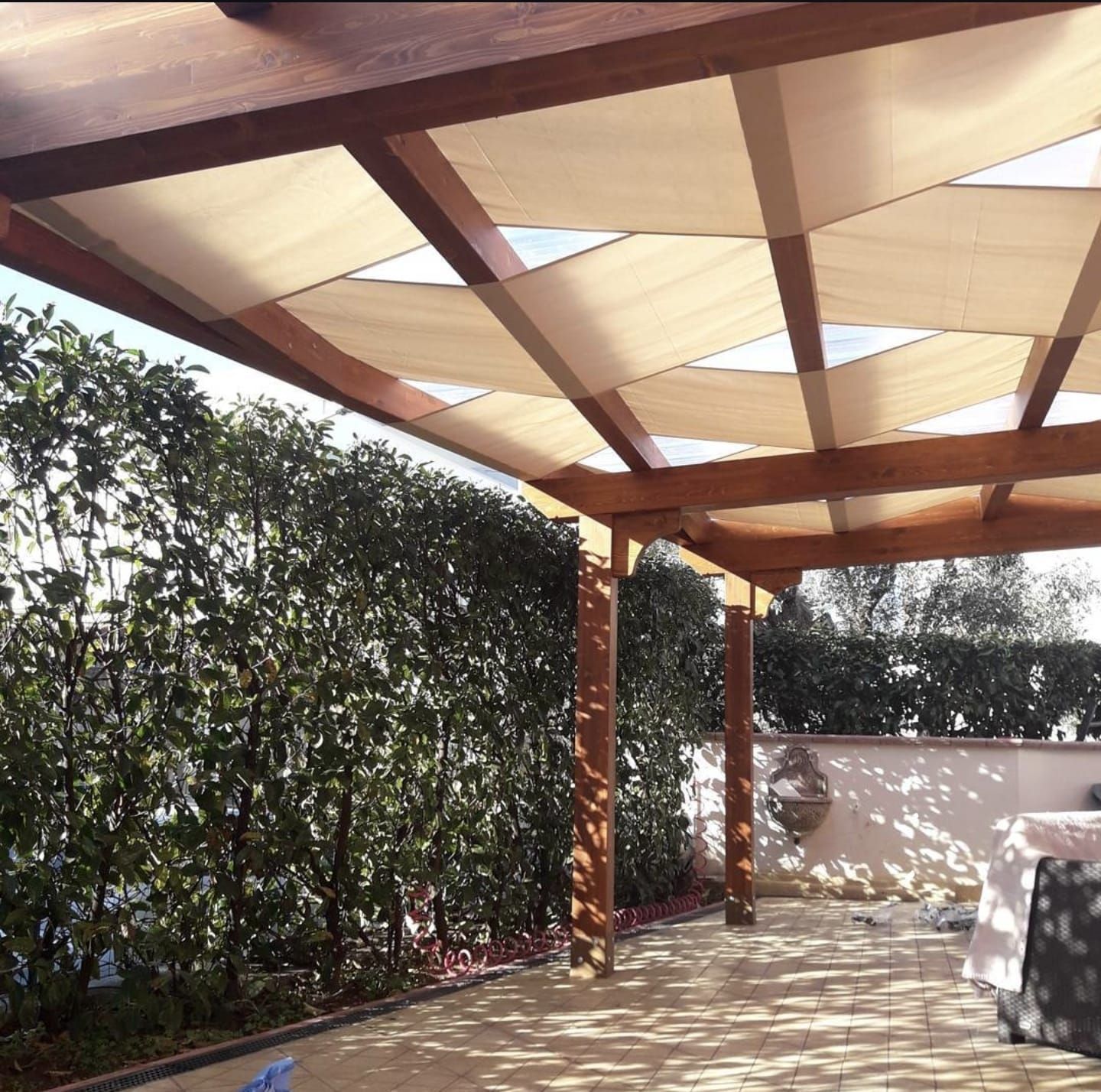 Un patio con struttura in legno e sovrastante tettoia