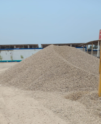 Un gran montón de grava se encuentra en medio de un campo de tierra