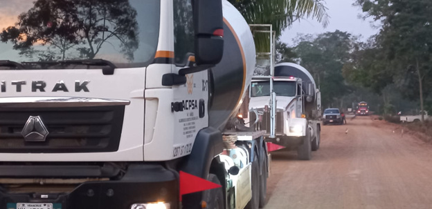 Una fila de camiones circula por un camino de tierra.