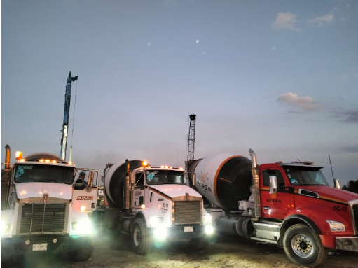 Tres camiones están estacionados uno al lado del otro en un campo