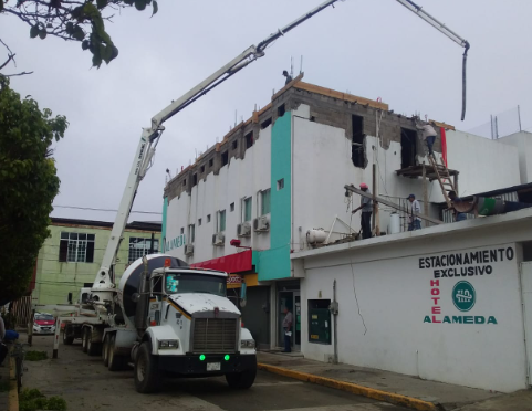 Un camión kenworth está estacionado frente a un edificio que dice estacionamiento