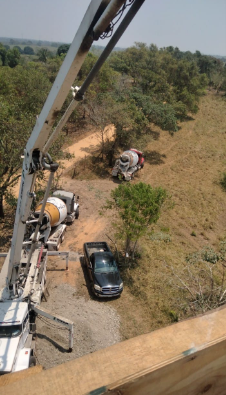 Un camión circula por un camino de tierra junto a una hormigonera.