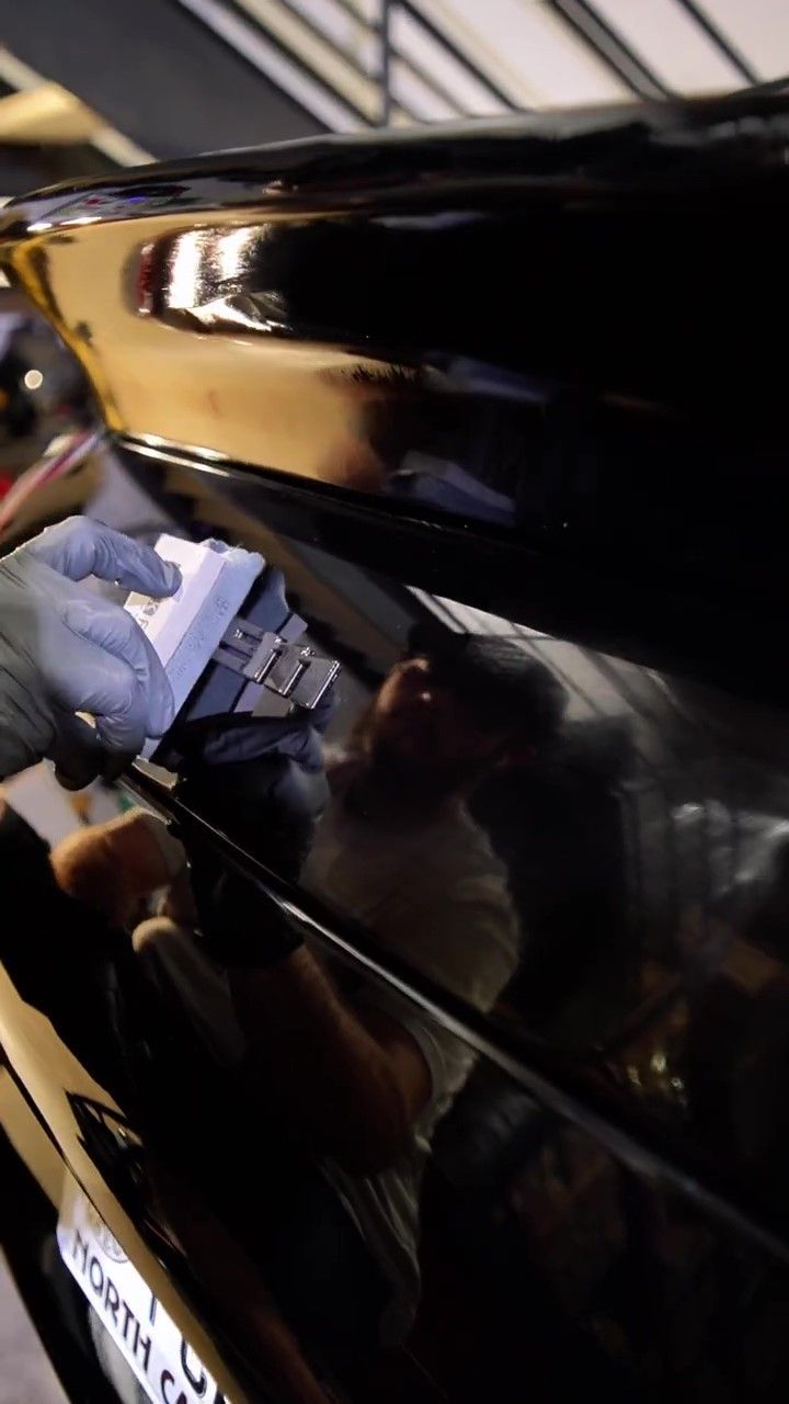 STEK Final Coat being applied by a professional auto detailer on a black Porsche 911.