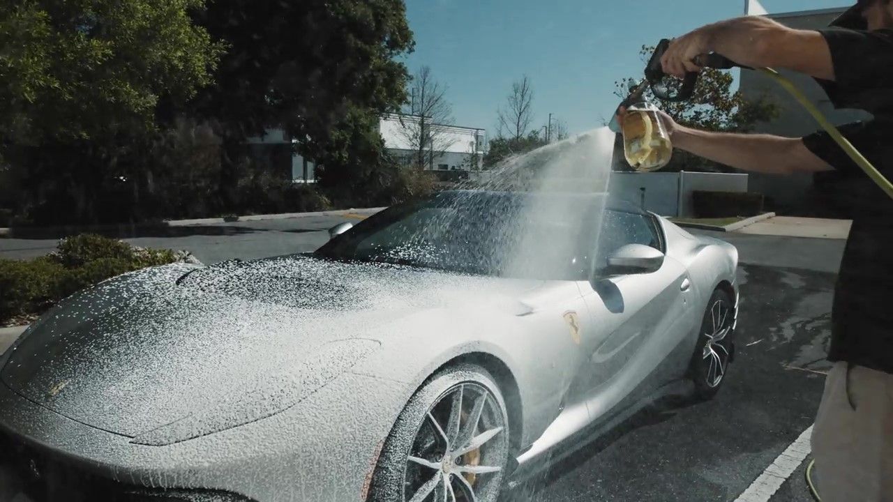 Washing ceramic coated car with pH-neutral shampoo using two-bucket method.