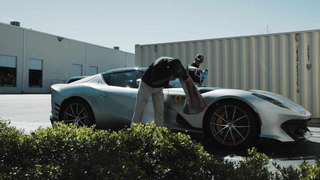 Drying ceramic-coated car with microfiber towel in sunny Florida.