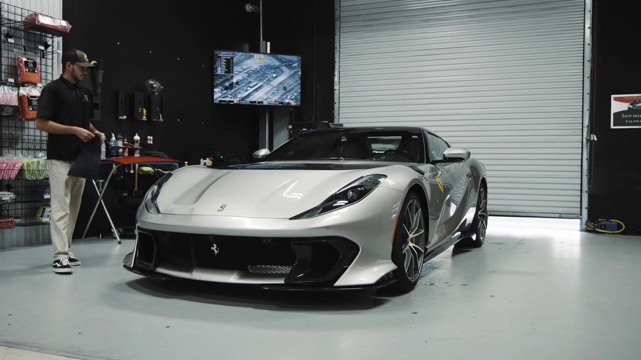 Applying ceramic booster spray to ceramic-coated car for Florida climate maintenance.