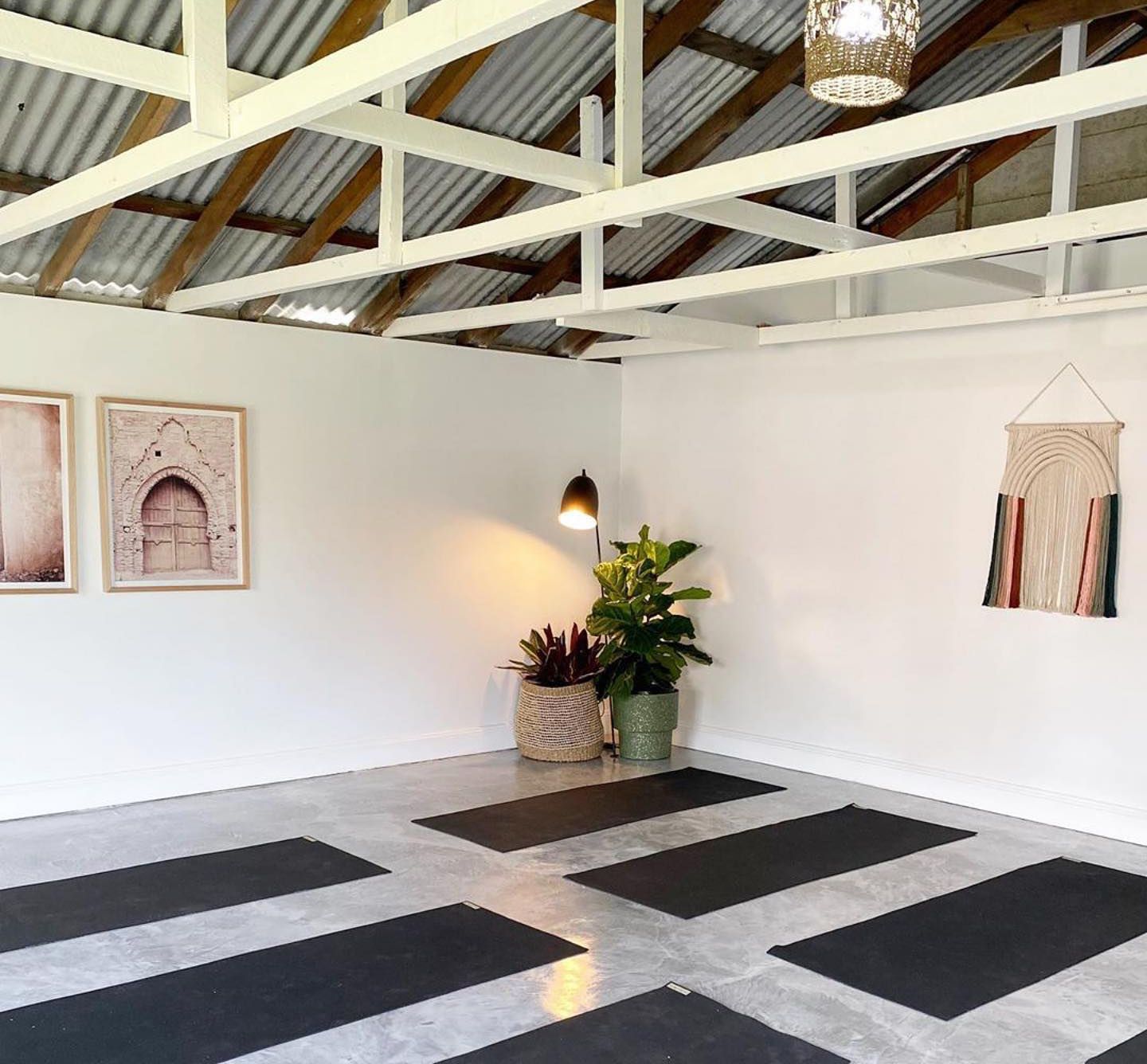 A room with a ceiling and a lot of yoga mats on the floor.