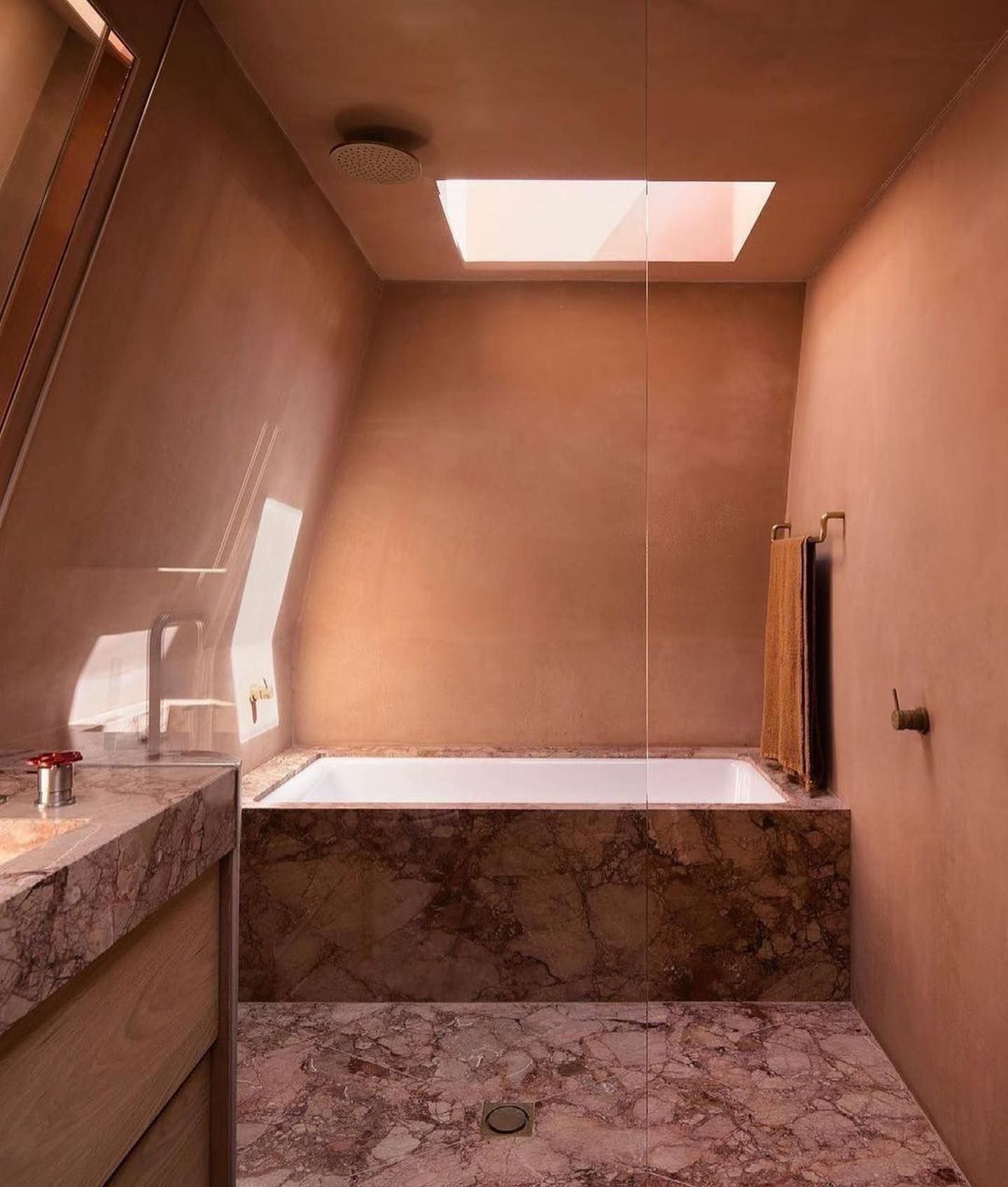 A bathroom with a tub and a skylight in the ceiling