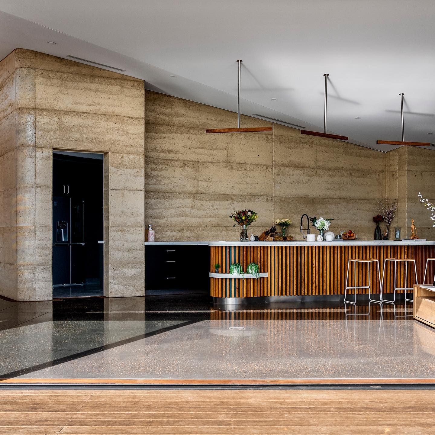 A kitchen with a wooden counter top and stools