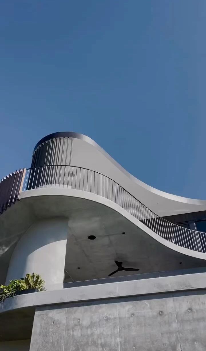 A building with a balcony and a ceiling fan on top of it.