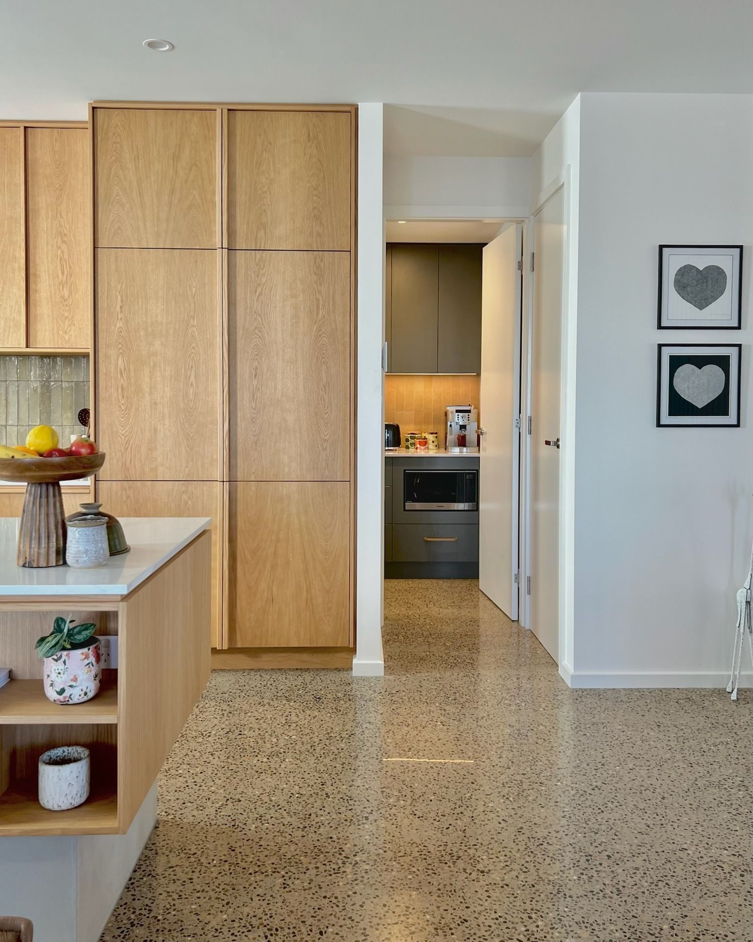 A kitchen with wooden cabinets and a terrazzo floor
