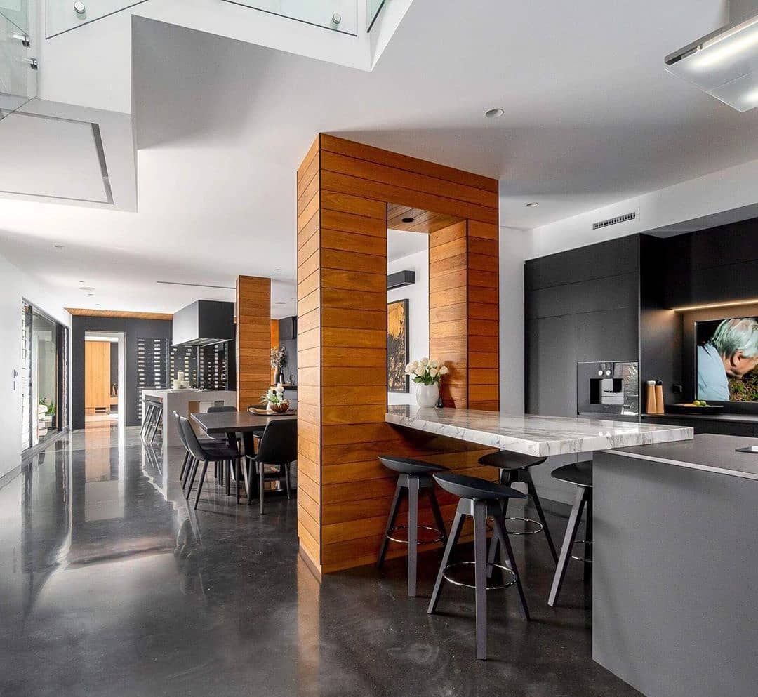 A kitchen with a wooden pillar in the middle of it